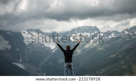 happy traveler on the top of mountain stormy landscape