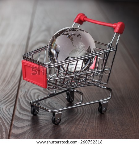 glass globe in the shopping trolley global market concept