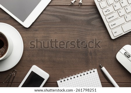 overhead of office table with notebook, computer keyboard and mouse, tablet pc and smartphone. copy space