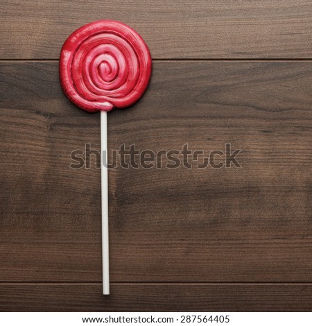 red sugar lollipop on the wooden table