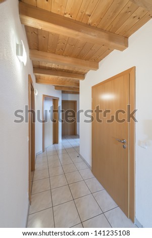 Corridor in an apartment with doors and white tiles
