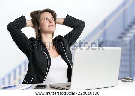 Image of a business woman sitting at her desk dreaming