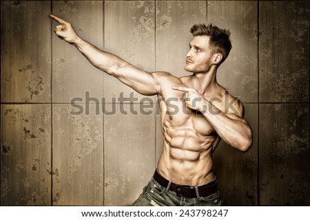 Posing young well trained man with perfect abdominal and pectoral muscle