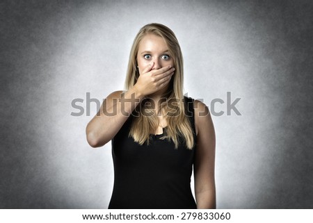 Blonde shocked woman holding anxiously the hand over mouth