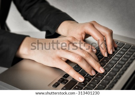Closeup of hands of a business woman typing on a laptop