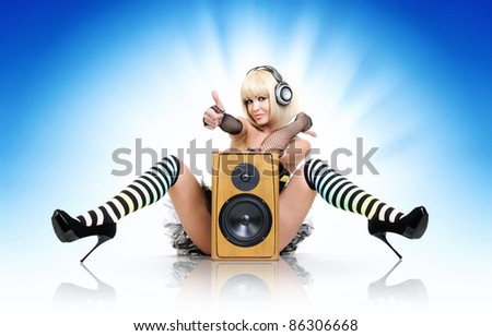 Glamorous sexy party girl in headphones with speaker, happy sound concept