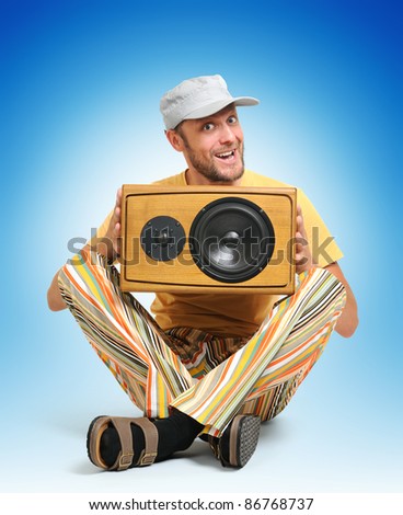 Party man with wooden speaker on blue background