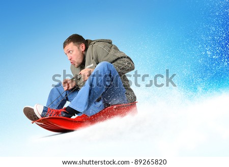 Young man flies on sled in the snow, concept winter sport