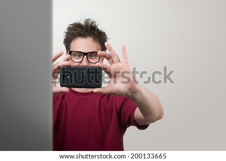 Man in glasses photographed by smartphone