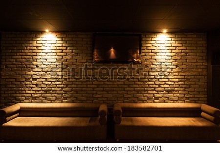 Old type brick wall texture front face and two sofas with local lighting