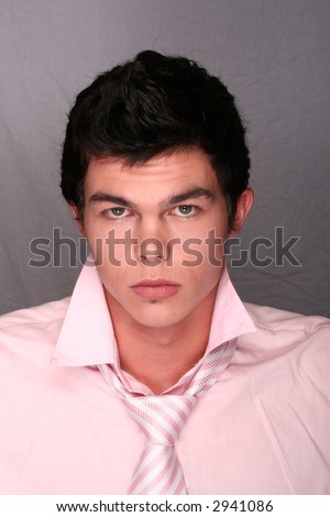 Young man in pink shirt on grey background