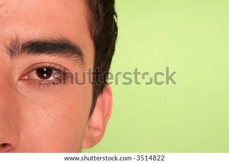 Half Young mans face on green background