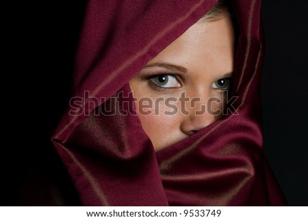 Mystery woman in red veil with beautiful green eyes with blond hair