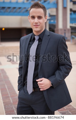Confident young and arrogant businessman wearing dark suit.