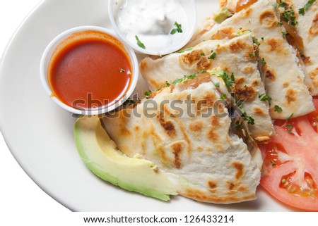 Plate of smoked salmon and avocado quesadillas on white plate with sour cream and sauce. Isolated on white.
