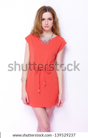 portrait of a beautiful young female in red dress standing posing