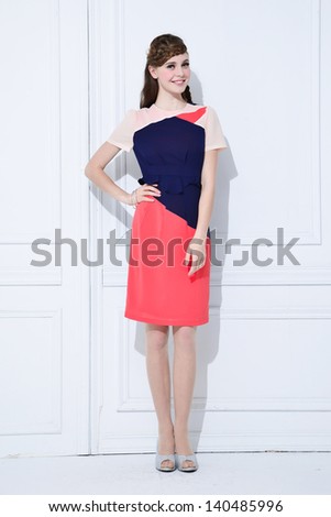 Full length young fashion model posing standing and looking in camera