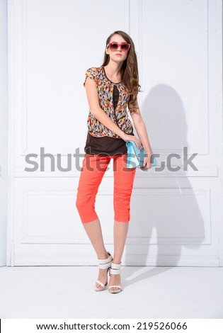 Full body portrait of a beautiful young female with handbag standing posing