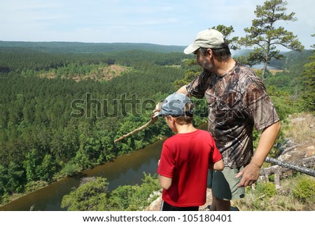 Adult and child standing on a mountaintop near the Arkansas River. The father shows his son the sights