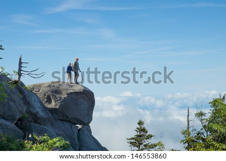 Above the clouds. Father and son on a rock in the National Park Great Smoky Mountains