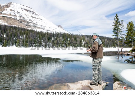 Man fishing in mountain Mirror Lake.   Uinta-Wasatch-Cache National Forest, Utah