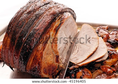 Roast Pork with apples and onion.  This is a delicious joint of roast pork cooked with onions, thyme and apples, partly caramelized.  With carving knife.