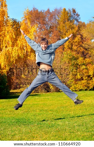 happy teenager jumping in the autumn park