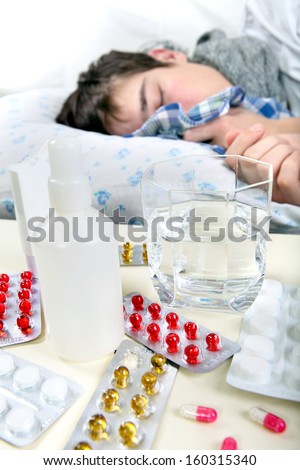 Sick Young Man sleeps with Pills on foreground. Focus on the Pills