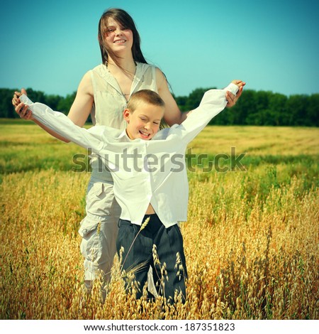 Toned photo of Happy Brother and Sister at the Wheat Field