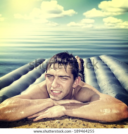 Toned photo of Happy Young Man on the Inflatable Beach Mattress