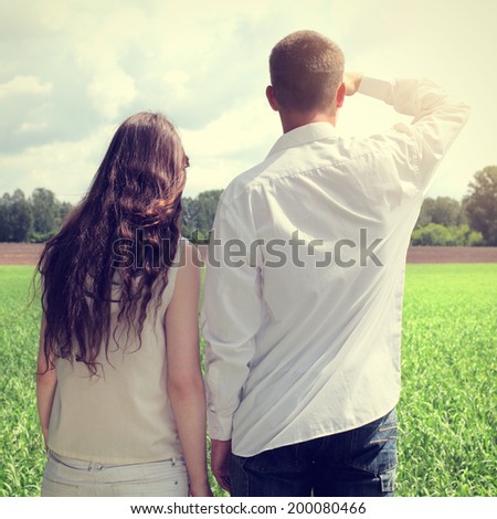 Toned photo of Young Man and Young Woman at the Summer Field