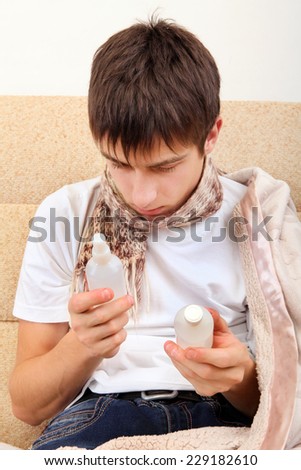 Sick Teenager choice the Medicine on the Sofa at the Home