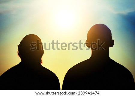 Toned Photo of Two Friends silhouette on evening sky background