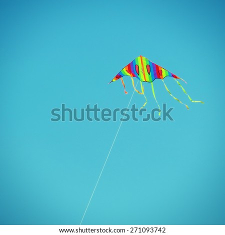 Toned Photo of Fly a Kite on the Blue Sky Background