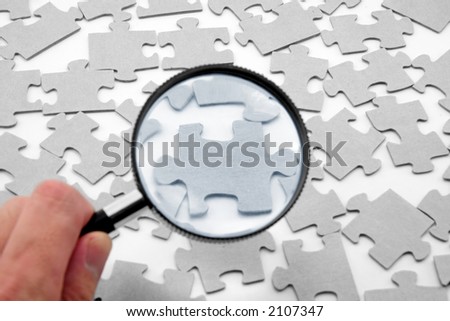 puzzle and magnifier, business concept