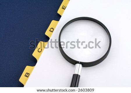 yellow file divider and magnifier, office supplies, close up