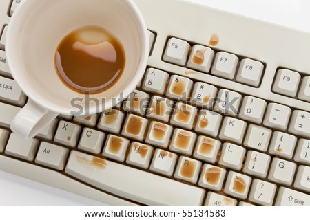 Coffee and damaged computer keyboard close up