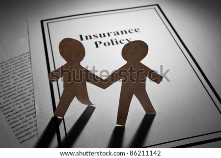 Insurance Policy and Paper Chain Men close up