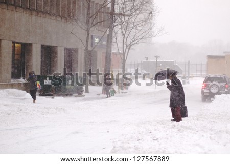TORONTO - FEBRUARY 8: Pedestrian crosses the snow-covered street. The biggest snow storm in five years hits Toronto on February 8, 2013.