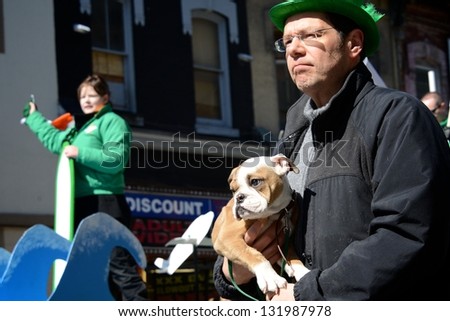 TORONTO - MARCH 17: Man and puppy watch the parade. Toronto\'s annual St. Patrick\'s Day parade takes place under sunny skies on Sunday afternoon March 17, 2013 in Toronto.