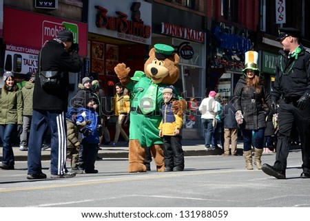 TORONTO - MARCH 17: People take photos with the mascot. Toronto\'s annual St. Patrick\'s Day parade takes place under sunny skies on Sunday afternoon March 17, 2013 in Toronto.