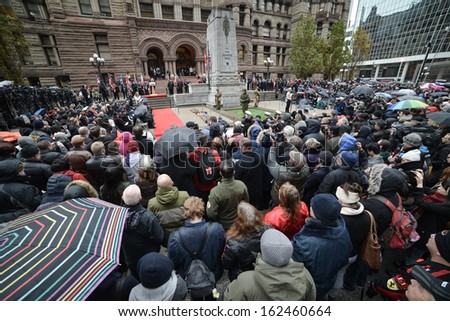 TORONTO - NOVEMBER 11: People attend Remembrance Day Services at Old City Hall Cenotaph in Toronto on November 11, 2013.