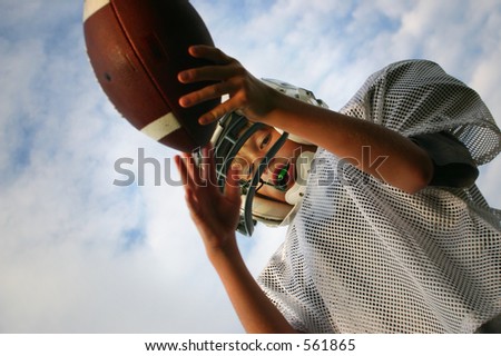 boy catching football, taken from below