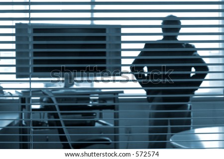 businessman  looking out window standing next to HD widescreen television
