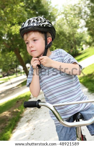 Boy putting on a bike helmet