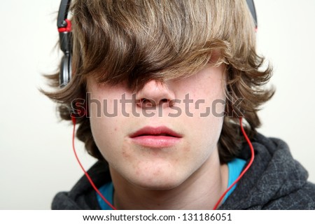 Teenager listening to music, hiding behind his hair
