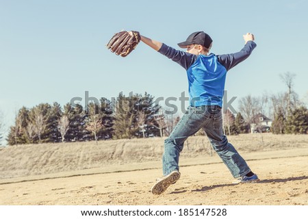 Boy pitching a baseball in the early spring