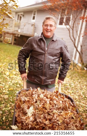 Senior man cleaning up fall leaves