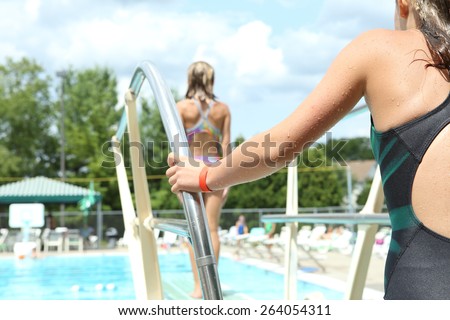 Girls diving off a diving board at a neighborhood pool