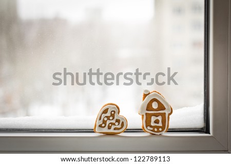 Loneliness. Christmas gingerbread cookies on the winter window with snow with copy space for your text
